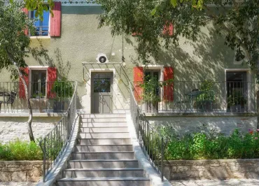 Vue de l'entrée de la maison avec une partie de la cour et du jardin