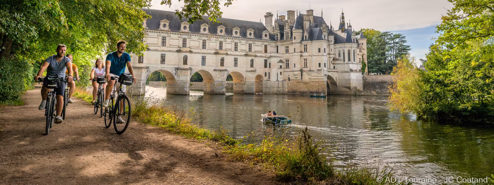 Cyclistes au bord du Cher devant le château de Chenonceau