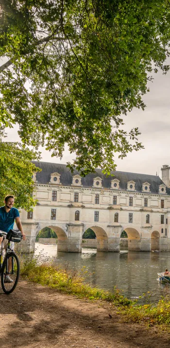 Cyclistes au bord du Cher devant le château de Chenonceau