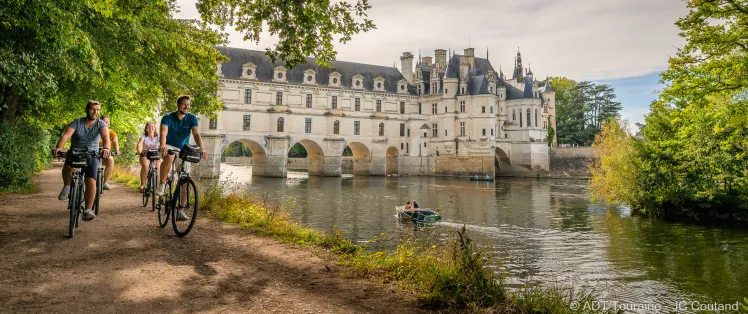 Cyclistes au bord du Cher devant le château de Chenonceau
