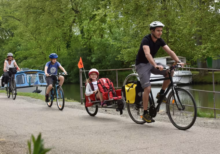 Famille à vélo avec enfants et remorque