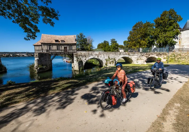 Cyclistes en voyage devant le vieux Moulin à colombage de Vernon