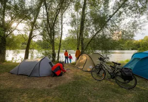 Cyclotouriste installant sa tente dans un camping Accueil Vélo