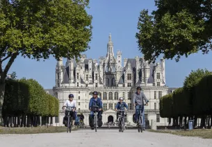 Devant le château de Chambord à vélo 