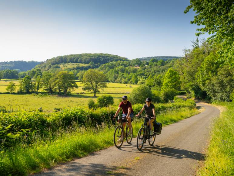 Des cyclistes pédalant sur la Vélobuissonnière au cœur des Alpes Mancelles 